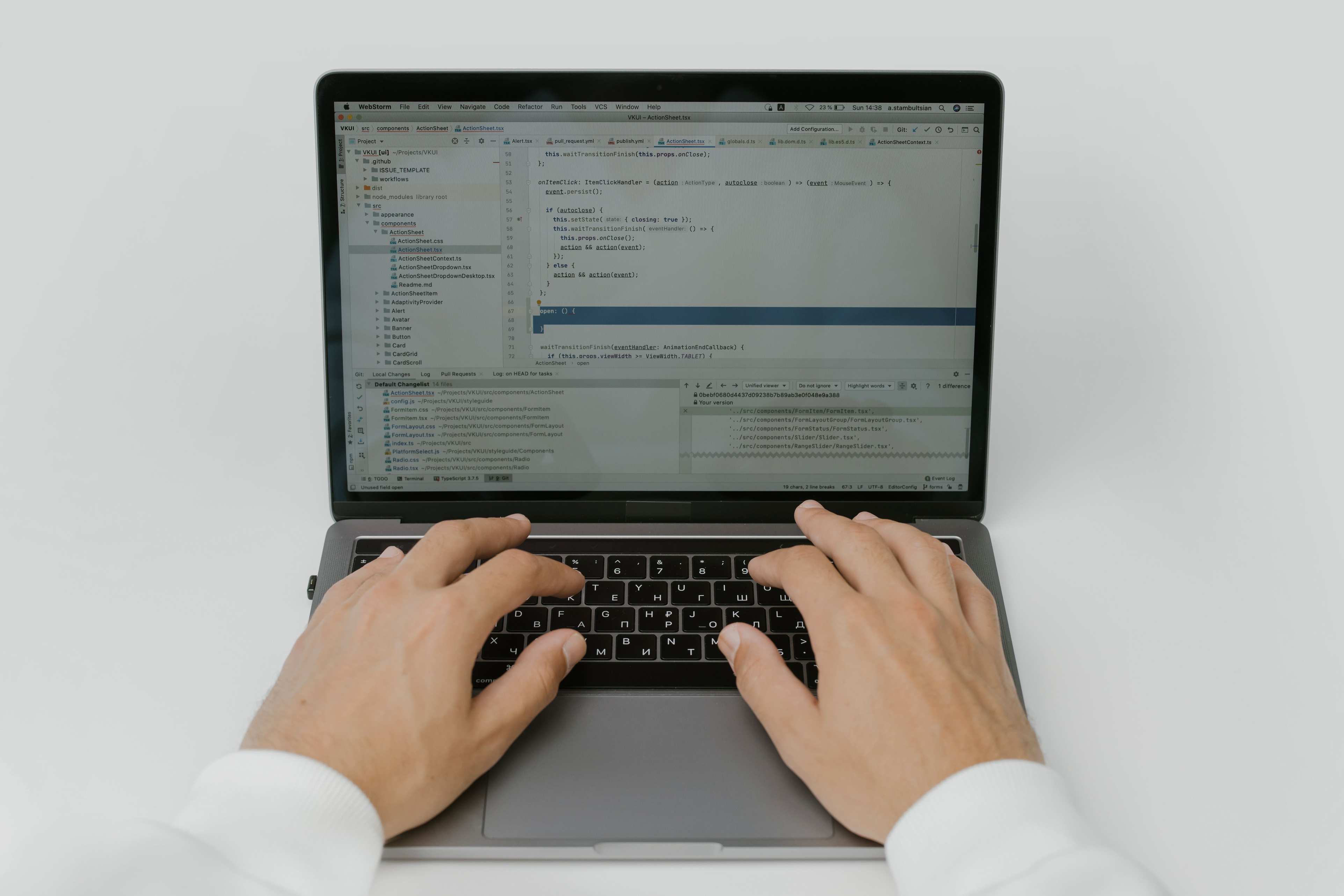 Developer workstation with code on screen, hands coding on a laptop